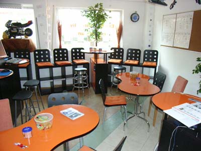 Unterrichtsraum mit orangen Tischen